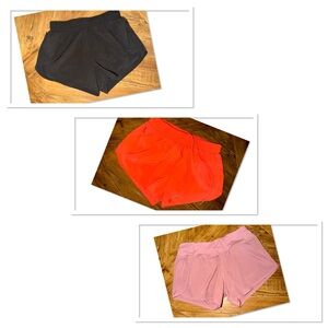 3 pairs of size small athletic shorts in black, orange, and pink
